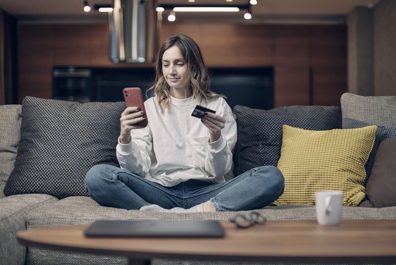 women sitting on a couch with a phone