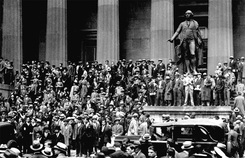 A crowd of people standing in front of a statue of George Washington on Wall Street during the Stock Market Crash in 1929.